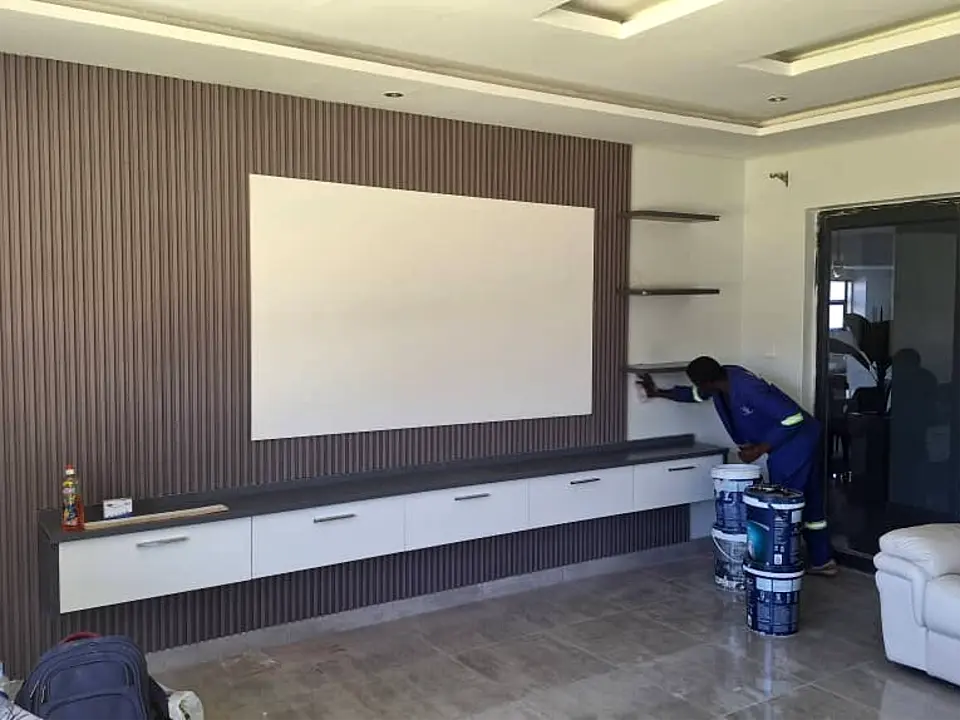 CSO installer fitting a fluted panel TV wall in a living room